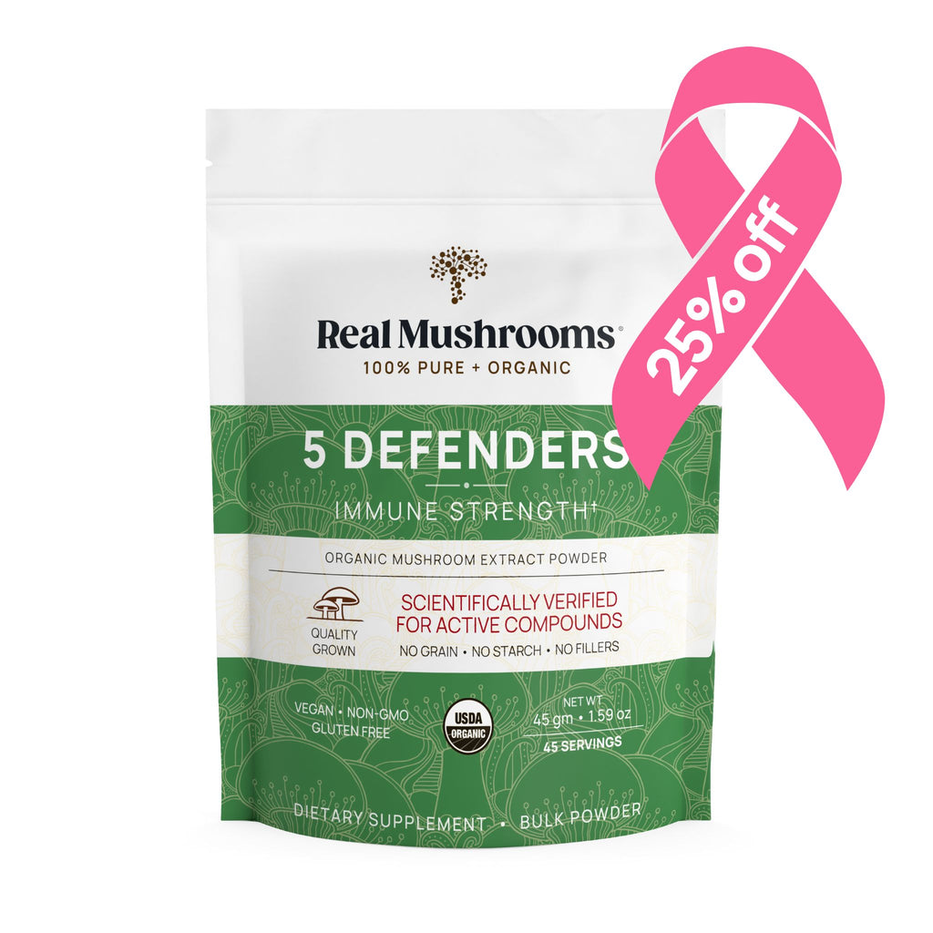 A package of Real Mushrooms 5 Defenders Organic Mushroom Complex – Bulk Powder with a 25% off pink ribbon badge. The label highlights its USDA Certified Organic ingredients, no gluten, no grain, no starch, and no fillers, featuring powerful Beta-glucans from organic mushroom extract.