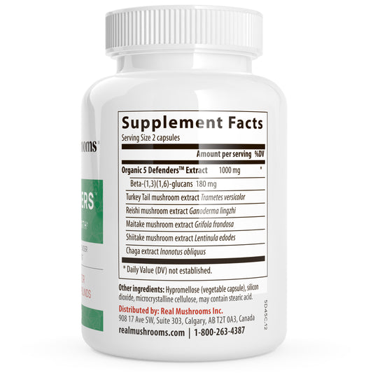 The Real Mushrooms 5 Defenders Organic Mushroom Blend Capsules come in a white bottle labeled "Supplement Facts" and contain beta-glucans from organic turkey tail, reishi, shiitake, maitake, and chaga. Serving size: 2 gluten-free capsules.