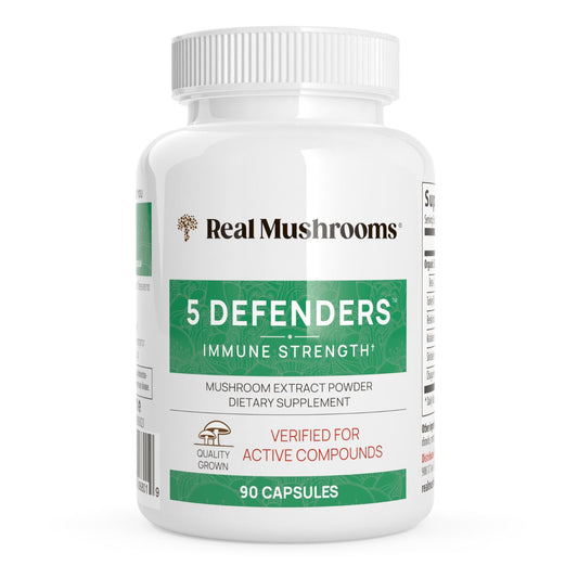 A white bottle labeled "Real Mushrooms 5 Defenders® Organic Mushroom Blend Capsules" contains 90 capsules with organic mushrooms for daily immune support.