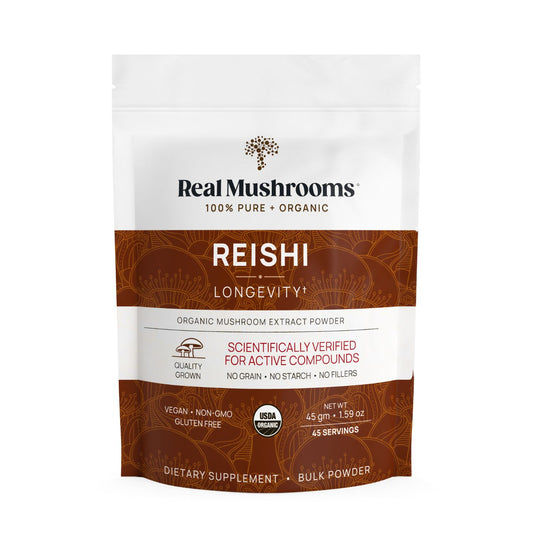 A white and brown pouch labeled "Real Mushrooms Organic Reishi Mushroom Powder – Bulk Extract" features quality and dietary claims on the front, highlighting organic Reishi mushroom benefits and premium beta-glucans.