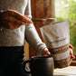 In the warmth of a sunlit window, someone scoops from a bag of Real Mushrooms' Lion’s Mane Mushroom Powder into their mug, enhancing cognitive function with each spoonful.